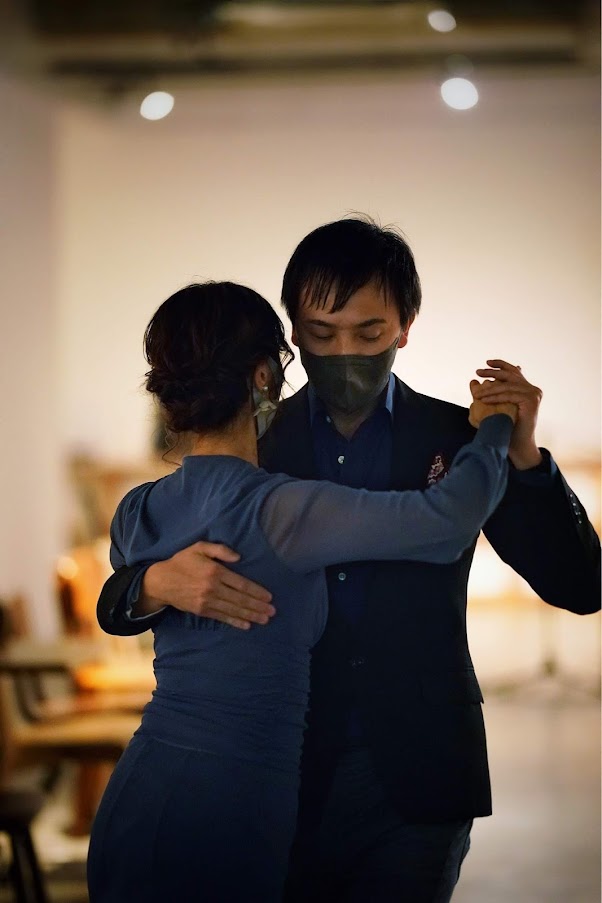 講師の先生が手を取り、導きながら男女ペアでダンスを踊っている光景