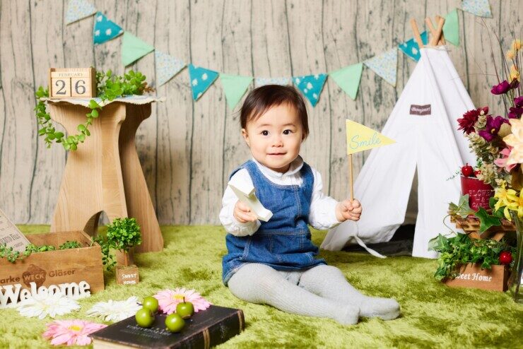 子供がマットの上に座りモデル撮影している写真
