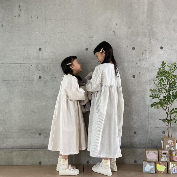 女の子2人が白いワンピースを着て、向かい合い、立っている様子
